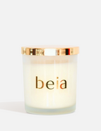 Beia candle with a gold lid on a white background