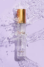 Hydrating Setting Spray on purple background with water splashing